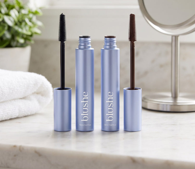 Two Blushe tubes on a marble counter, one with a black wand and one with a brown wand
